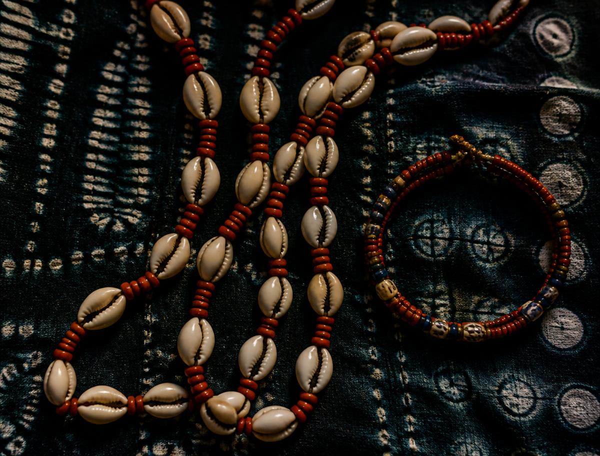 Cowrie shell and coral bead strands on indigo cloth